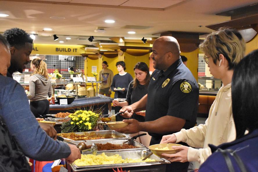 Students and TUPD officer serving himself food from a buffet station.